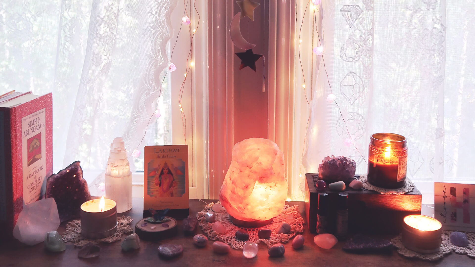 A cozy and mystical self-care altar featuring a glowing Himalayan salt lamp, candles, crystals, oracle cards, and twinkling fairy lights against sheer lace curtains. A perfect space for mindfulness, relaxation, and manifestation.